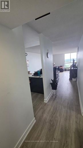 Toronto (Brookhaven-Amesbury) condo for rent - A long hallway with a chair and a table in the distance.