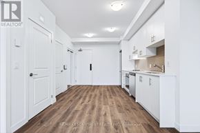 Hamilton (Lakeshore) condo for rent - A white kitchen with wooden floors and white cabinets.