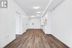 Hamilton (Lakeshore) condo for rent - A long, empty hallway with wooden floors and white walls.