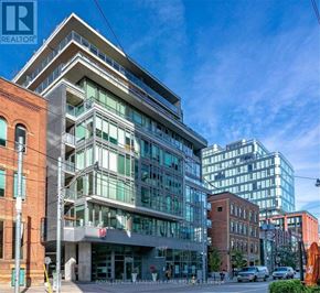 Toronto (Waterfront Communities) condo for rent - A modern building with glass windows is the focal point of the image.