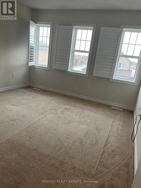 Brampton (Northwest Brampton) apartment for rent - A room with a carpeted floor and three windows.