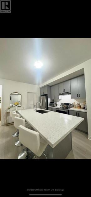 New Tecumseth (Tottenham) townhouse for rent - A modern kitchen with a large island and white chairs.
