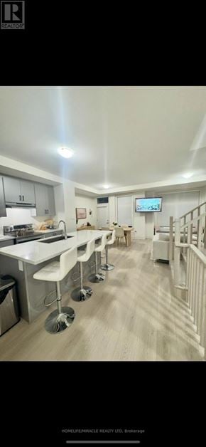New Tecumseth (Tottenham) townhouse for rent - A well-lit, modern kitchen with a dining area and a TV mounted on the wall.
