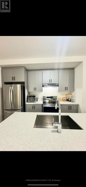 New Tecumseth (Tottenham) townhouse for rent - A kitchen with a sink and a refrigerator.