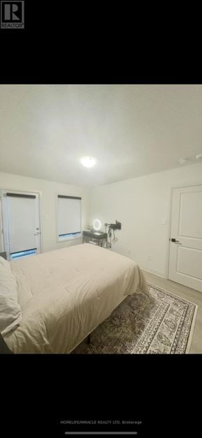 New Tecumseth (Tottenham) townhouse for rent - A bedroom with a bed and a rug.