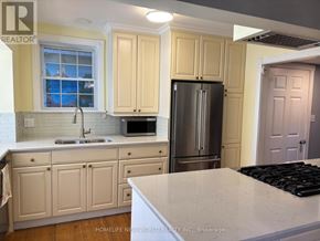 Toronto (High Park-Swansea) apartment for rent - A kitchen with a sink, refrigerator, and cabinets.