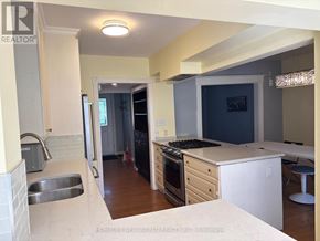 Toronto (High Park-Swansea) apartment for rent - A kitchen with a sink, stove, and refrigerator.