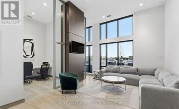Milton (Co Coates) condo for rent - A modern living room with a grey sofa and a glass table.
