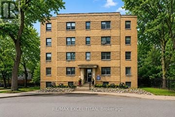 Toronto (Yonge-St. Clair) condo for rent - A tall brick building with a blue sign in front that says RE/MAX EXCEL TITAN Brokerage.