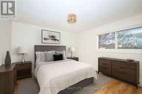 Welland (Lincoln/Crowland) multi-family for rent - A bedroom with a bed, nightstands, and a framed picture on the wall.