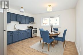 Welland (Lincoln/Crowland) multi-family for rent - A kitchen with blue cabinets and a dining table with four chairs.