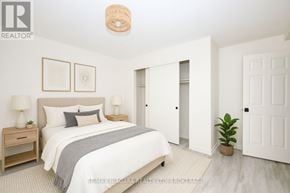 Welland (Lincoln/Crowland) multi-family for rent - A bedroom with a bed, nightstands, and a plant.