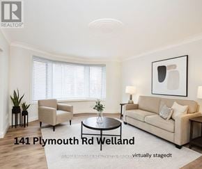 Welland (Lincoln/Crowland) multi-family for rent - A living room with a beige couch, a chair, a coffee table, and a painting on the wall.