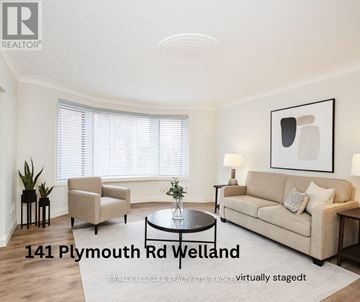 Welland (Lincoln/Crowland) multi-family for rent - A living room with a beige couch, a chair, a coffee table, and a painting on the wall.