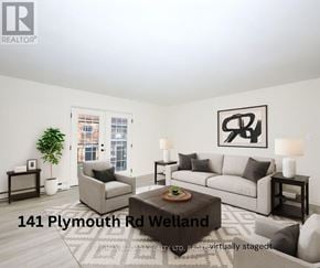 Welland (Lincoln/Crowland) multi-family for rent - A living room with a grey couch, a coffee table, and a large window.