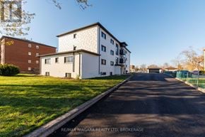 Welland (Lincoln/Crowland) multi-family for rent - A white building with a black roof is situated on a street with a green lawn in front.