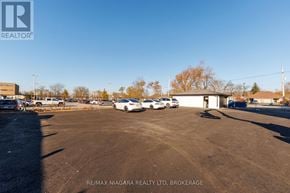 Welland (Lincoln/Crowland) multi-family for rent - A parking lot with several cars and a building in the background.