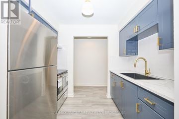 Welland (Lincoln/Crowland) multi-family for rent - A kitchen with a stainless steel refrigerator and a sink with a gold faucet.