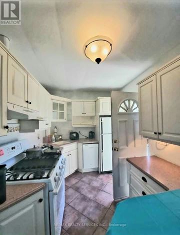 Hamilton (Ainslie Wood) apartment for rent - A kitchen with white cabinets and a stove top oven.