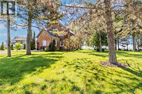Merlin apartment for rent - A house with a red brick exterior is surrounded by trees and grass.