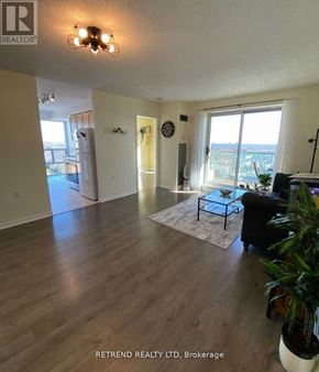 Toronto (Willowdale East) condo for rent - A living room with a couch, a coffee table, and a plant.