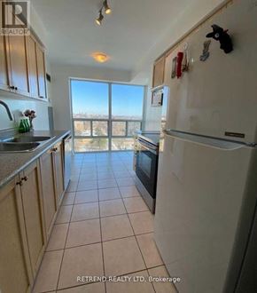 Toronto (Willowdale East) condo for rent - A kitchen with a refrigerator, sink, and cabinets with a view of the outdoors.