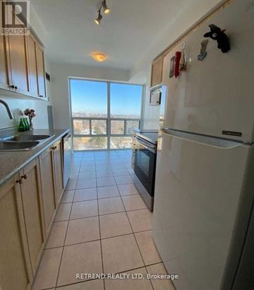 Toronto (Willowdale East) condo for rent - A kitchen with a refrigerator, sink, and cabinets with a view of the outdoors.