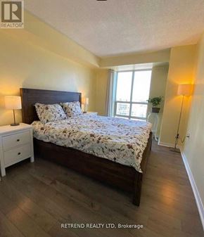 Toronto (Willowdale East) condo for rent - A bedroom with a large bed and a nightstand.