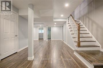 Newmarket (Stonehaven-Wyndham) apartment for rent - A spacious hallway with wooden floors and a staircase.