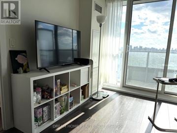 Toronto (Henry Farm) condo for rent - A living room with a television and a large window.