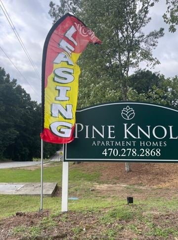 Jonesboro apartment for rent - A sign for Pine Knoll Apartment Homes is displayed in front of a grassy area.