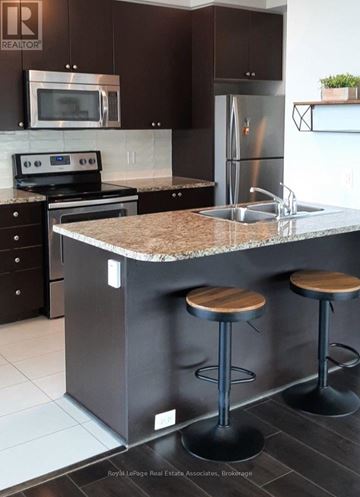 Mississauga (Creditview) condo for rent - A kitchen with a granite countertop and a refrigerator.