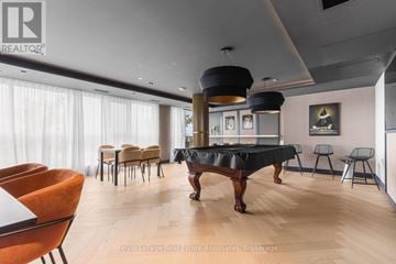 Oakville (Go Glenorchy) condo for rent - A living room with a black table and orange chairs.