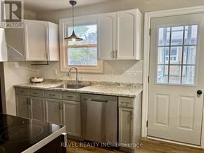 Shelburne apartment for rent - A kitchen with white cabinets and a black stove top oven.