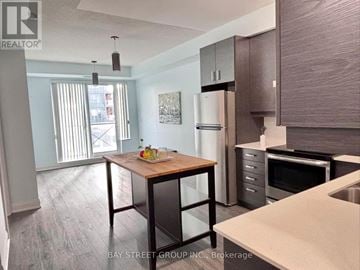 Markham (Unionville) condo for rent - A kitchen with a table and chairs in front of a refrigerator.