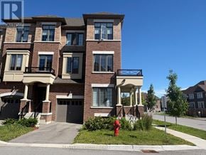 Whitby (Lynde Creek) townhouse for rent - A large brick building with a balcony and a fire hydrant in front.