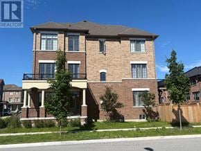 Whitby (Lynde Creek) townhouse for rent - A large brick house with a balcony in the middle.