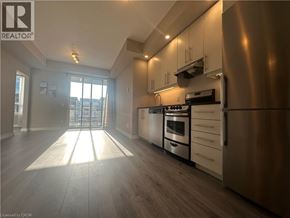 Grimsby condo for rent - A modern kitchen with stainless steel appliances and wooden flooring.