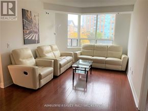 Toronto (Bendale) condo for rent - A living room with a large window, a coffee table, and two couches.