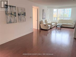 Toronto (Bendale) condo for rent - A living room with a white sofa and two chairs.