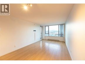 Richmond apartment for rent - A large empty room with wooden floors and a window overlooking a cityscape.