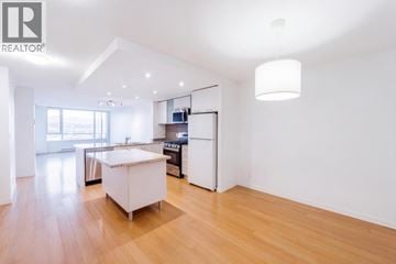 Richmond apartment for rent - A modern kitchen with wooden floors and white walls.