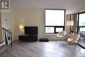 Toronto (Bay Street Corridor) condo for rent - A living room with a television, two chairs, and a staircase.