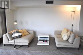 Toronto (Bay Street Corridor) condo for rent - Two grey couches with pillows and a coffee table in a living room.