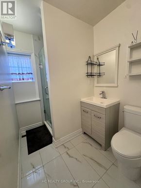 Toronto (Newtonbrook East) apartment for rent - A white bathroom with a toilet, sink, and mirror.