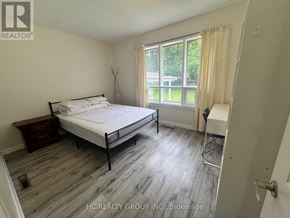 Toronto (Newtonbrook East) apartment for rent - A bedroom with a bed, nightstand, and chair.