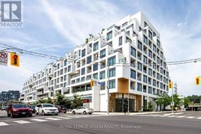 Toronto (Casa Loma) condo for rent - A white multi-story building with a glass entrance and balconies.