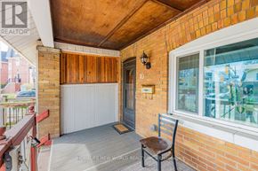 Toronto (The Beaches) apartment for rent - A balcony with a wooden bench and a window overlooking a patio.
