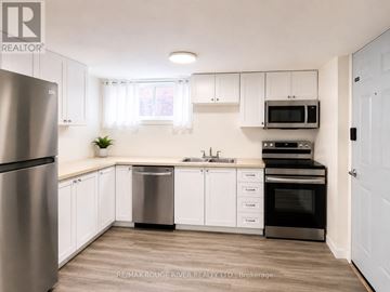 Welland (Prince Charles) apartment for rent - A kitchen with white cabinets and a stainless steel refrigerator.