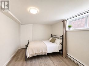 Welland (Prince Charles) apartment for rent - A bedroom with a bed, nightstand, and window.